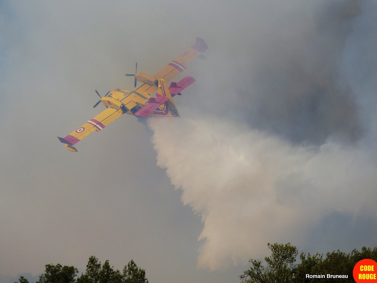 Un Canadair survole la zone de l'incendie en largant de l'eau