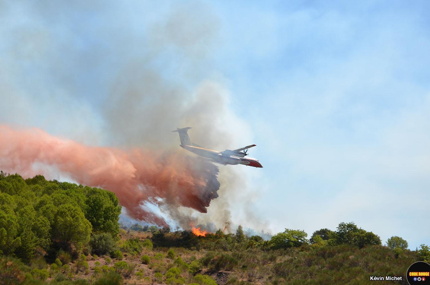 Un avion de la Sécurité Civile survole un incendie de forêt et largue du retardant