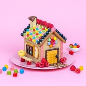Maison en gâteau décorée avec des bonbons et des biscuits