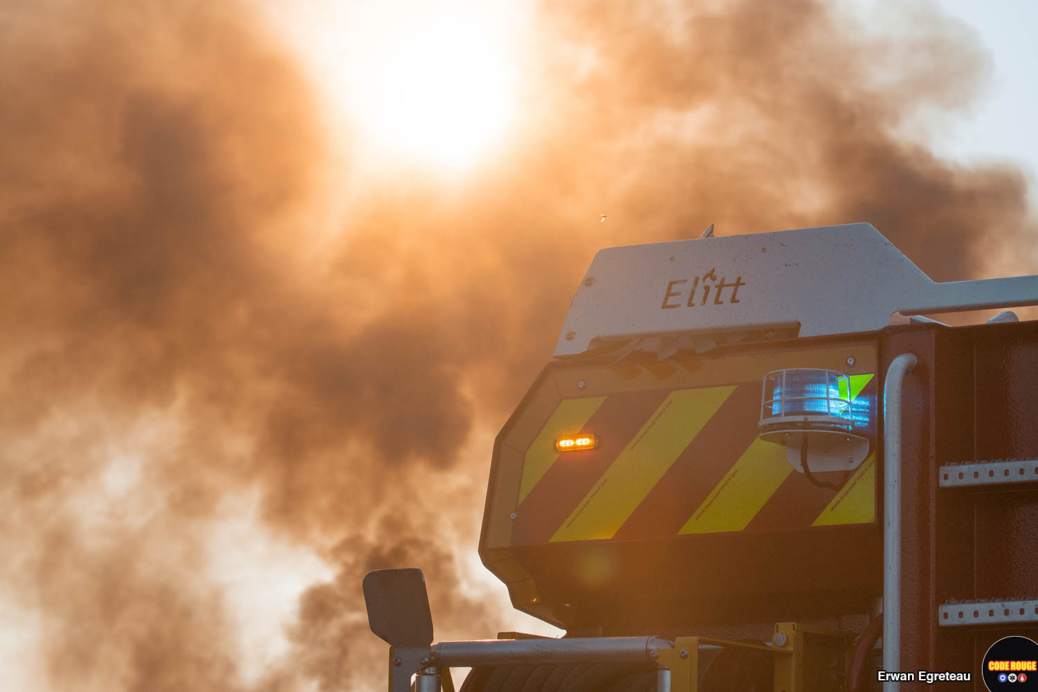 L'arrière d'un camion des sapeurs-pompiers au milieu de la fumée