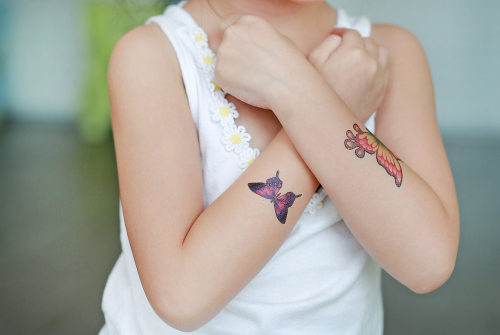 Petite fille avec tatouages de paillon sur les bras