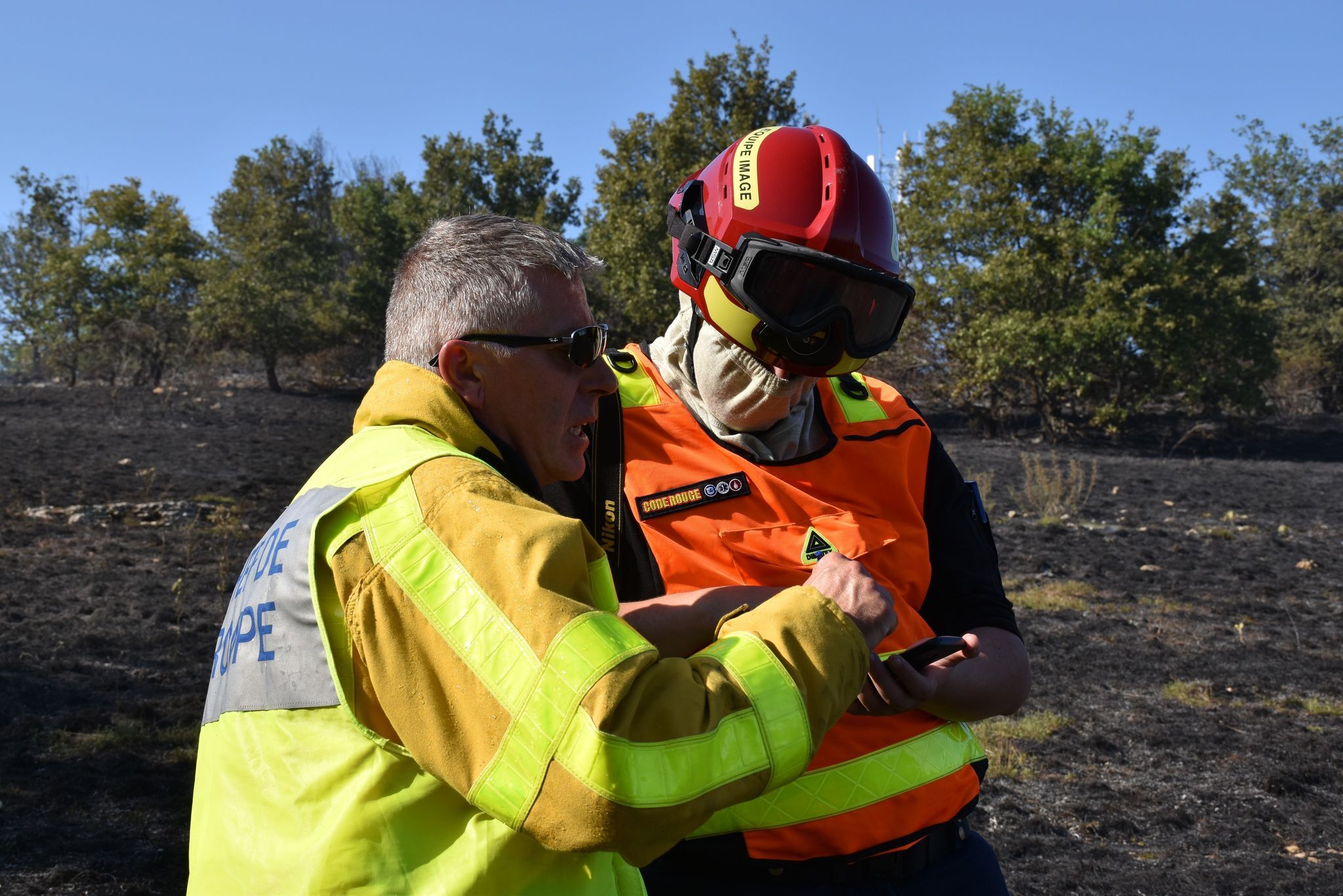 Un bénévole de l'association Code Rouge Info en intervention discute avec un pompier de la Sécurité Civile