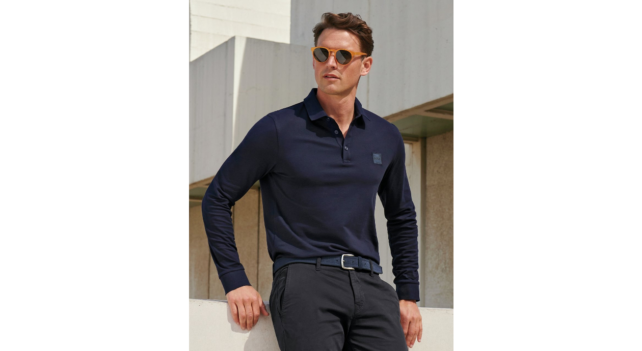 Homme avec lunettes de soleil portant un polo manches longues bleu-marine