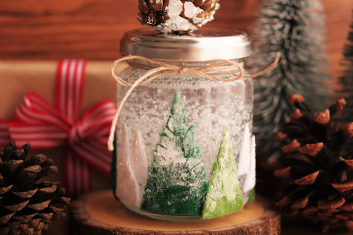 Boule à neige maison faite avec un bocal et de la feutrine en guise de sapins de Noël