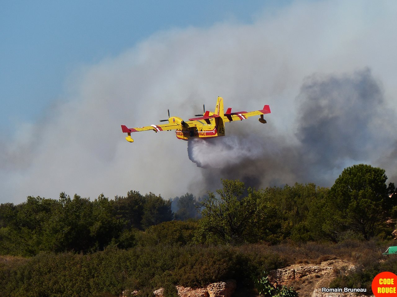 Un Canadair survole la zone de l'incendie en largant de l'eau