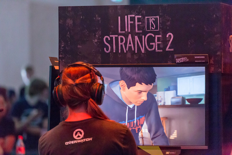 Une femme debout devant un écran diffusant le jeu Life is Strange