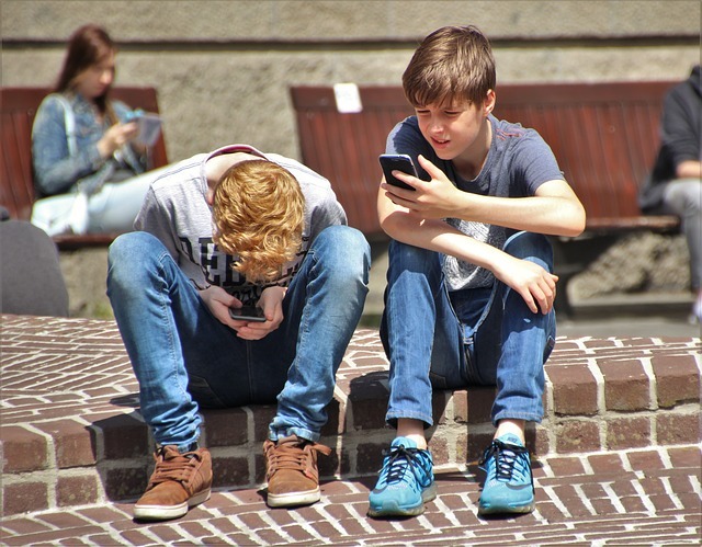 Deux ados utilisant leurs téléphones