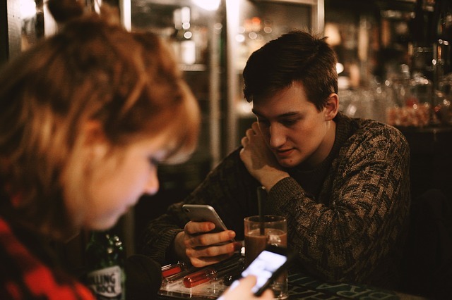 Une femme et un homme utilisant leurs téléphones 