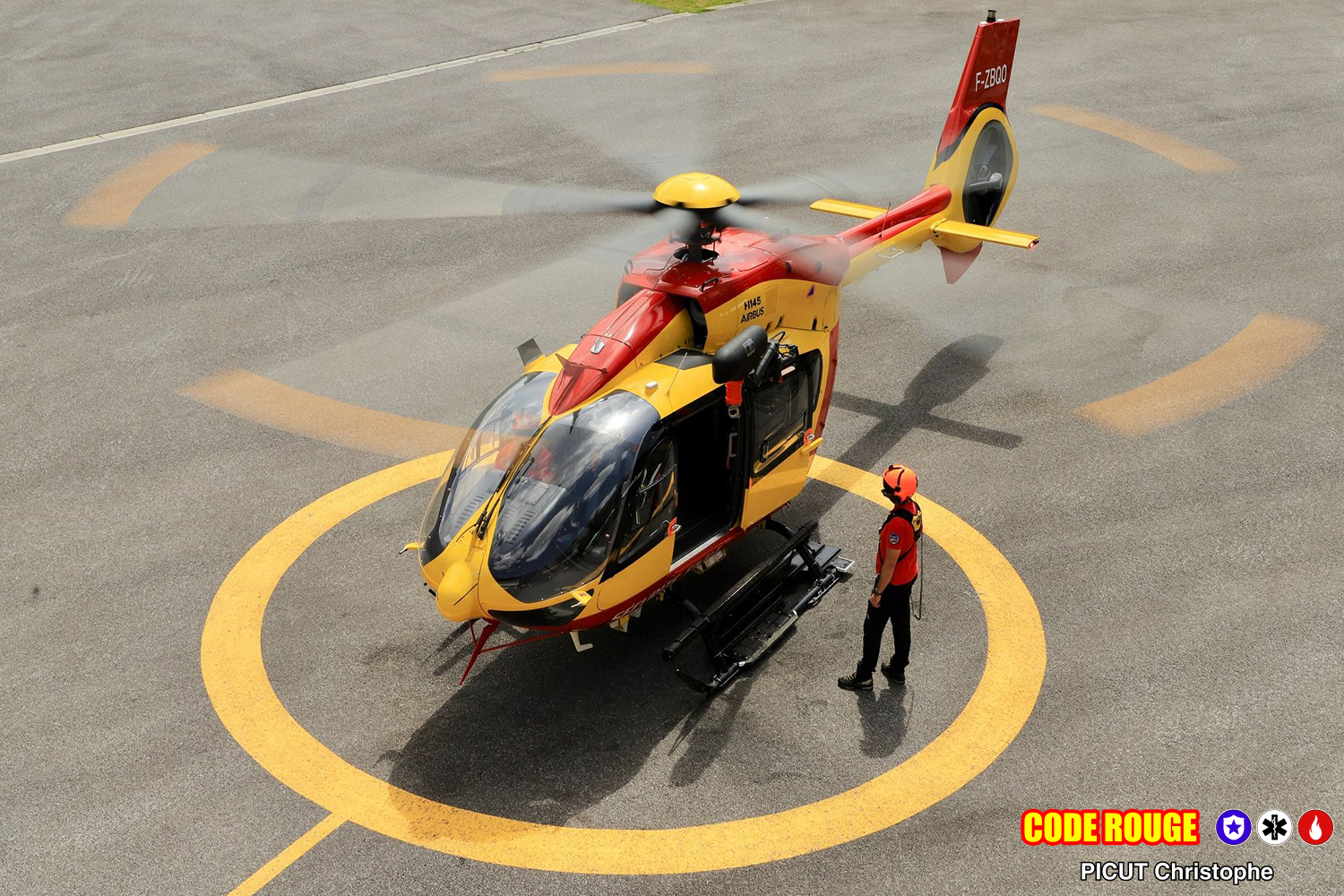 Un hélicoptère de la Sécurité Civile au sol, avec un agent debout à côté