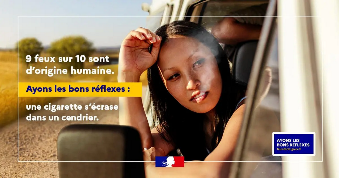 Un homme est accroupi près d'un feu de camp dans une forêt