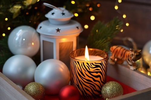 photophore a motif jungle et figurine de tigre parmi les traditionneles boules de Noël