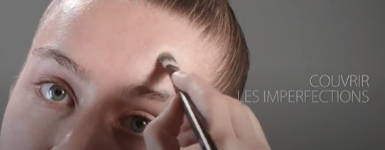 Une femme appliquant du maquillage sur son visage