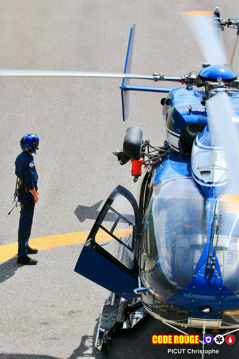 Un hélicoptère de la gendarmerie au sol, avec un agent debout à côté